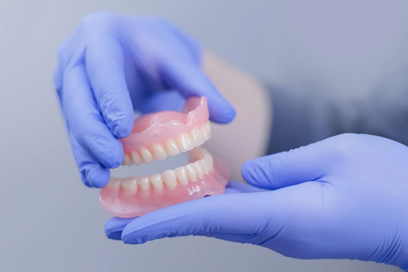 A dentist holding a set of dentures