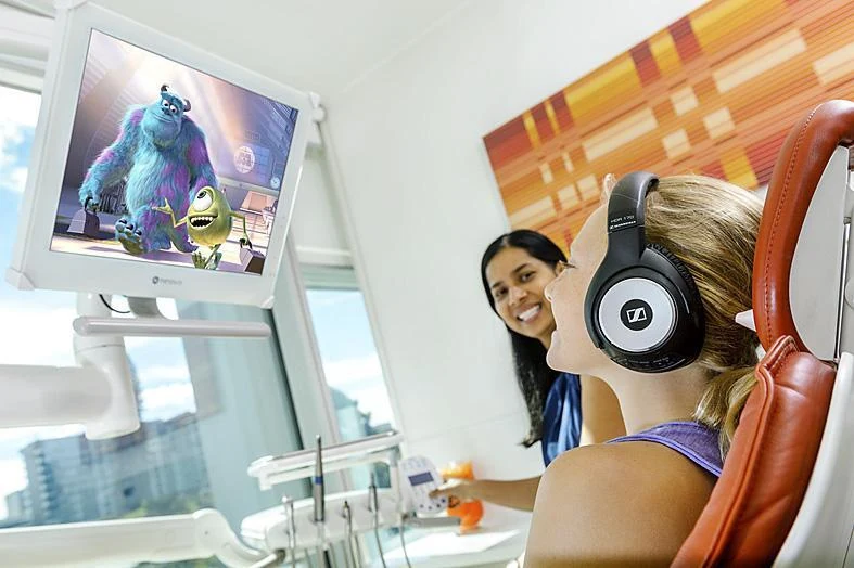 A patient watching a film on the ceiling screen during treatment